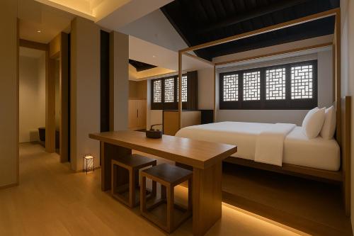 a bedroom with a bed and a table and a desk at cloud and wind in Yangzhou