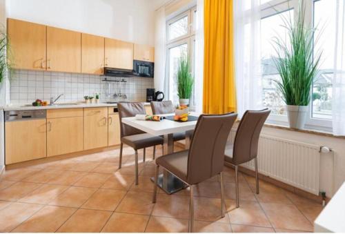 a kitchen with a table and chairs in a room at Villa Rosenhof in Norderney