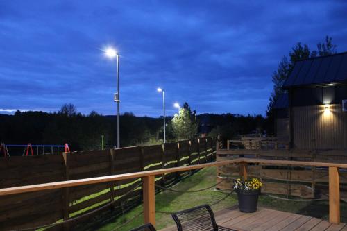 a deck with a wooden fence and a bench at Domki Fajnie.Tu in Łączna