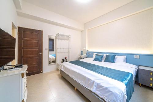 a bedroom with a blue and white bed and a television at 十月 Mooon House in Jiaoxi