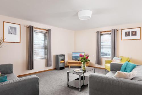 a living room with two couches and a tv at Starfish Accommodation in Whitby