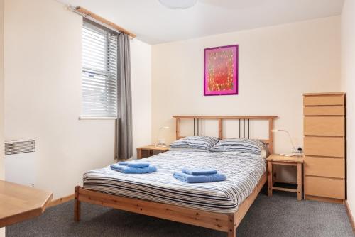 a bedroom with a bed with two blue towels on it at Starfish Accommodation in Whitby
