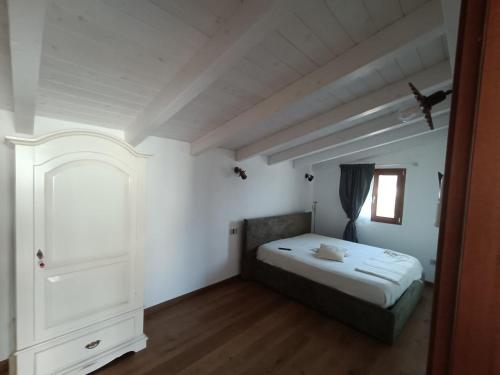 a small bedroom with a bed and a window at Country house pura natura Alghero in Casa Minnina