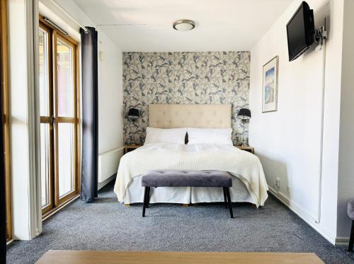 a bedroom with a bed and a tv on a wall at Hotell Bistro Port Sud in Skärhamn