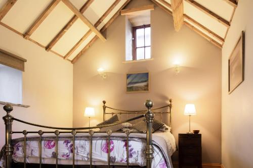a bedroom with a bed and a window at Sebright Cottage, Borrowby Farm Cottages in Staithes