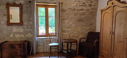 a room with a chair and a table and a window at Karádi-Berger Vendégház in Erdőbénye