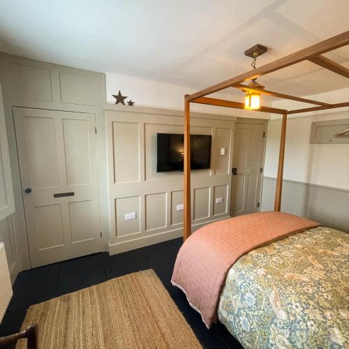 a bedroom with a bed and a flat screen tv at Helvellyn Cottage in Penrith