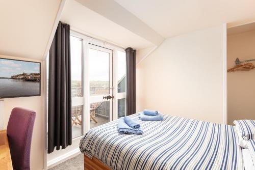 a bedroom with a bed and a large window at Silver Street Suites in Whitby