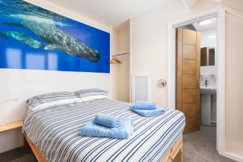 a bedroom with a bed with blue towels on it at Silver Street Suites in Whitby