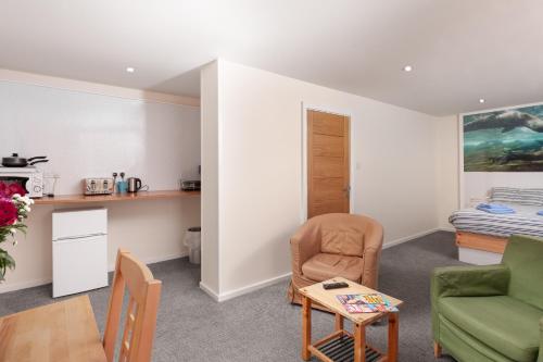 a living room with a chair and a table at Silver Street Suites in Whitby