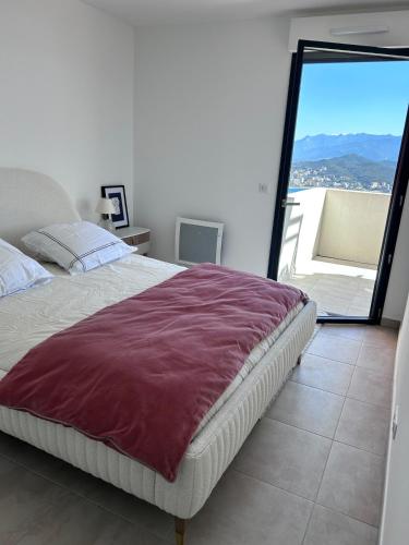 une chambre avec un grand lit avec une grande fenêtre dans l'établissement Beautiful Appartment Les terrasses de Torretta room sea view Ajaccio, à Ajaccio