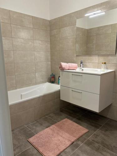 une salle de bain avec une baignoire et un lavabo et une baignoire dans l'établissement Beautiful Appartment Les terrasses de Torretta room sea view Ajaccio, à Ajaccio