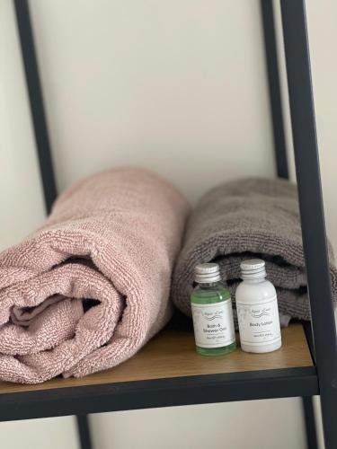 two towels and two bottles of medicine on a shelf at Wendy's Tiny Beachhouse in Noordwijk