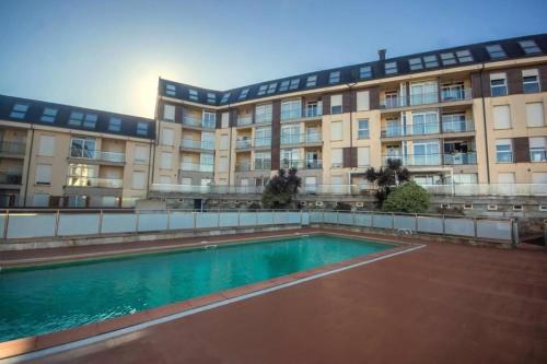 a building with a swimming pool in front of a building at Ático Paraíso in San Ciprián