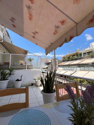 a patio with a table and chairs and an umbrella at Qqueen House in Piraeus