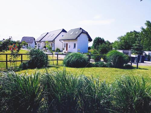 una casa en un patio con valla y césped en Mistral Jarosławiec, en Jarosławiec