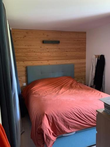 - une chambre avec un lit rouge et une tête de lit en bois dans l'établissement Maison individuelle 130 m2 4 Chambres, à Embrun