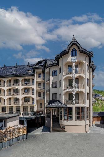 a large building with a clock on the front of it at Premium hotel & SPA in Bukovel