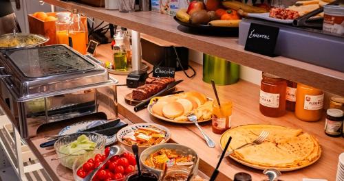 un buffet avec des assiettes de nourriture sur un comptoir dans l'établissement Hôtel Vendome Saint-Germain, à Paris