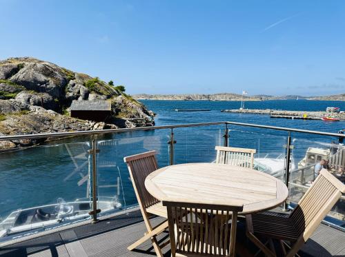 a wooden table and chairs on a deck with the water at Hotell Bistro Port Sud in Skärhamn