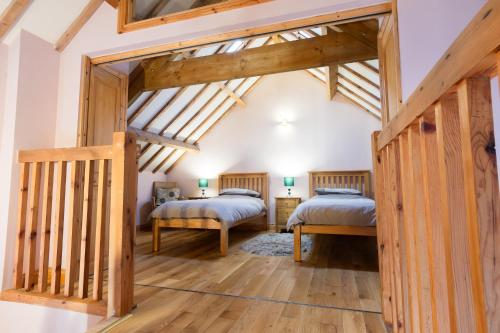 two beds in a room with wooden beams at Rosecombe, Borrowby Farm Cottages in Staithes