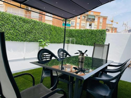 a table with chairs and an umbrella on a patio at Ático Fuengirola Playa Centro Ciudad in Fuengirola