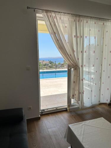 a living room with a large window and a sliding glass door at Beachfront House Robert with Pool in Cesarica