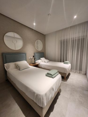 a bedroom with two beds and a large window at ELEVENLIGHTS-COSTABALLENA Garden View in Costa Ballena