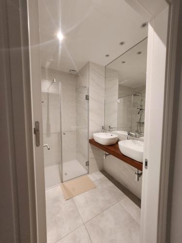 a bathroom with two sinks and a shower at ELEVENLIGHTS-COSTABALLENA Garden View in Costa Ballena