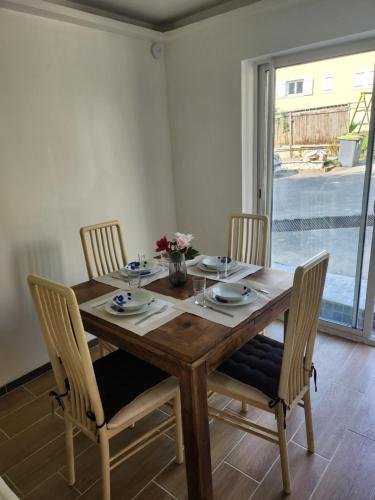 une table à manger en bois avec quatre chaises et une table dans l'établissement Petit appartement de charme, à Saint-Pierre-lès-Nemours