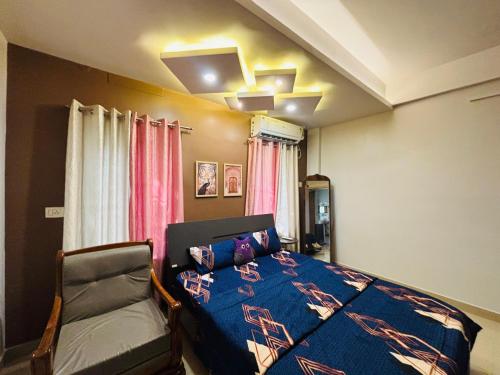 a bedroom with a bed and a chair in it at Miss Tea Home in Agartala