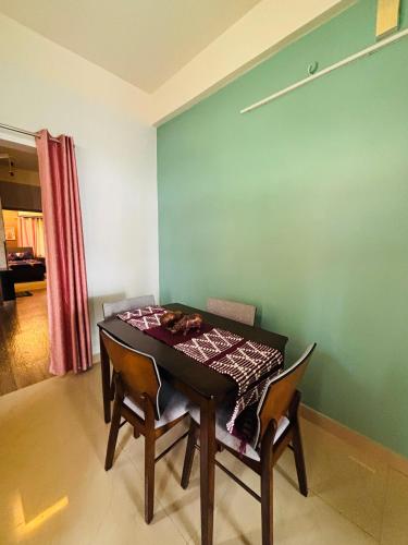 a dining room with a table and two chairs at Miss Tea Home in Agartala