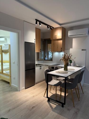 eine Küche und ein Esszimmer mit Tisch und Stühlen in der Unterkunft Scandi Golem in Durrës