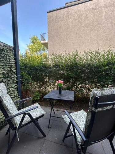 a patio with two chairs and a table with flowers at SALVIA II exklusiv & smart & Terrasse II Dein City-Apartment in Braunschweig