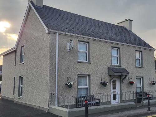 a large brick house with a black roof at Kesh self catering holiday home. in Kesh