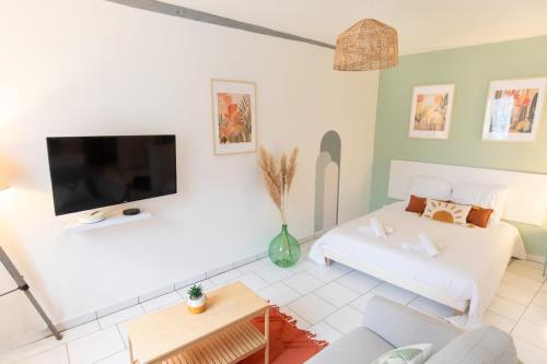 un soggiorno con un divano bianco e una TV a schermo piatto di Le Panama - 5 min du centre, 500m2 de jardin a Évreux