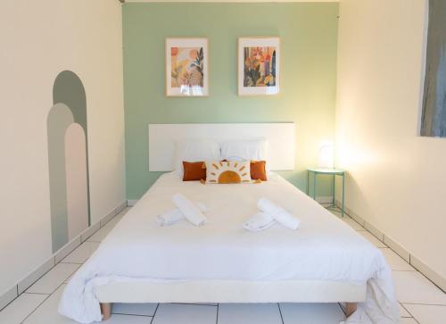 une chambre avec un lit blanc avec deux serviettes dessus dans l'établissement Le Panama - 5 min du centre, 500m2 de jardin, à Évreux