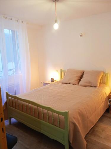 - un lit vert dans une chambre avec fenêtre dans l'établissement Résidence Maurice, à Ax-les-Thermes