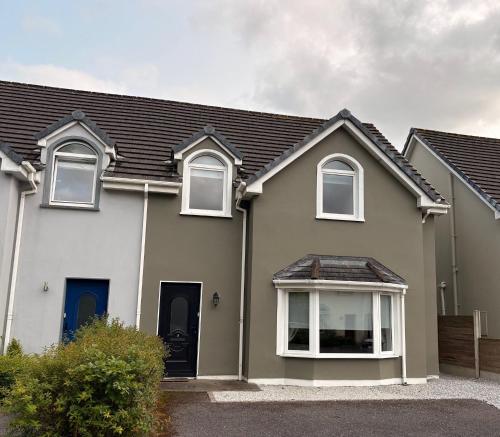 a white house with white windows at Spacious two bedroom home. Easy stroll from Kenmare town in Kenmare