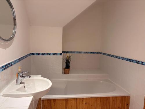 a white bathroom with a sink and a tub at Spacious two bedroom home. Easy stroll from Kenmare town in Kenmare