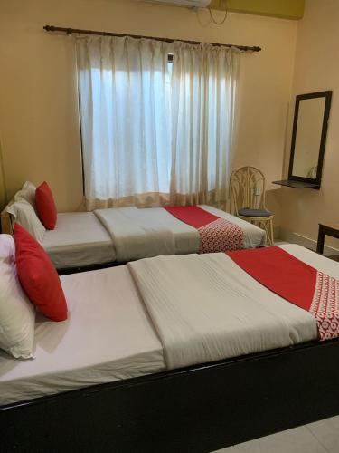 two beds in a room with a window at Hotel August International in Pokhara