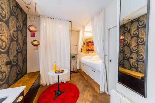 - une chambre avec un lit et une table avec un tapis rouge dans l'établissement Studio proche tour Eiffel - paris 15 -2P, à Paris