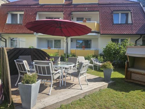 a patio with a table and chairs and an umbrella at Villa Viktoria Whg 5 - "Moosmuschel" in Kolpinsee