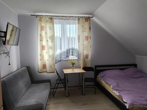 a bedroom with a bed and a chair and a window at Agroturystyka Zacisze nad Pilicą in Stromiec