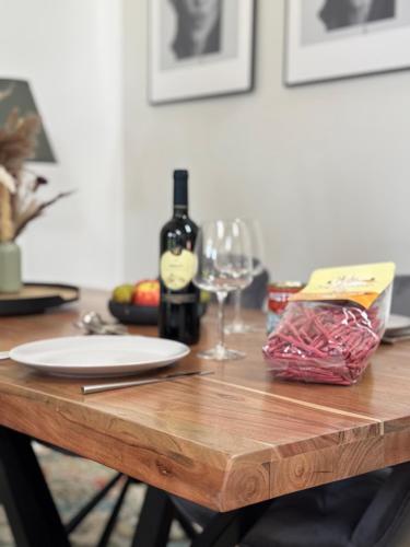 a wooden table with a bottle of wine and a glass at falternhof loft - geschichte trifft auf design in Höslwang