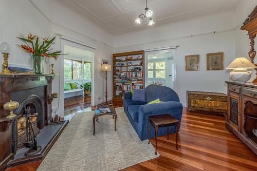 a living room with a blue chair and a fireplace at Tarran in Mount Tamborine