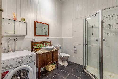 a bathroom with a washing machine and a toilet at Tarran in Mount Tamborine