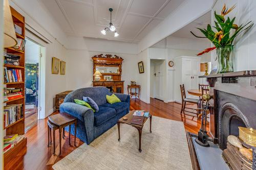 a living room with a blue couch and a fireplace at Tarran in Mount Tamborine