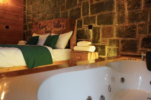 a bedroom with a bed and a bath tub at River Villas Resort in Çamlıhemşin