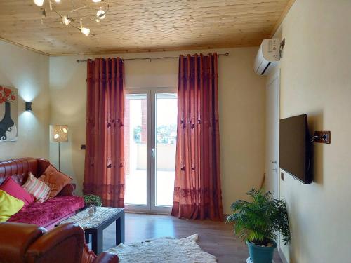 a living room with a couch and a large window at Hilltop Haven Cityview in Durrës